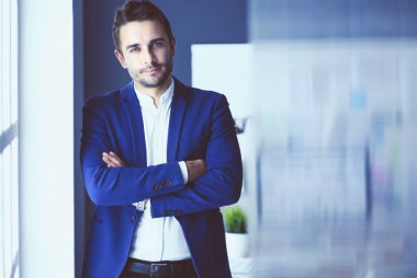 Dizüstü bilgisayar ve bilgisayar çalışırken önünde genç tasarımcı portresi.