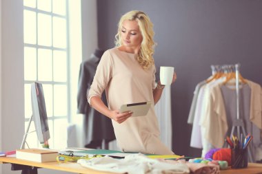 Moda tasarımcısı kadın stüdyoda tasarımları üzerinde çalışıyor..