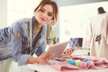 Onun tasarımları s iPad ile çalışan moda tasarımcısı kadın
