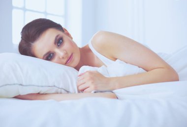 Genç ve güzel bir kadın yatakta yatıyor..