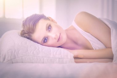 Genç ve güzel bir kadın yatakta yatıyor..