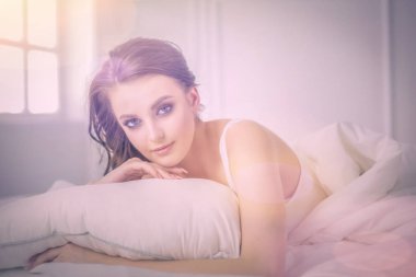 Genç ve güzel bir kadın yatakta yatıyor..