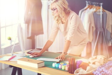 Moda tasarımcısı kadın stüdyoda tasarımları üzerinde çalışıyor..