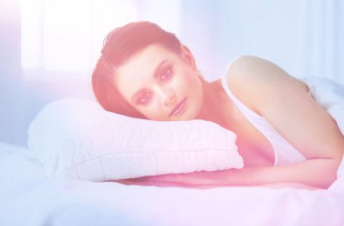 Genç ve güzel bir kadın yatakta yatıyor..