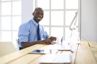 Kulaklıklı Afro-Amerikan işadamı laptopuyla çalışıyor.