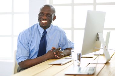 Kulaklıklı Afro-Amerikan işadamı laptopuyla çalışıyor.