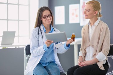 Doktor ve hasta masada otururken bir şey tartışıyorlar. İlaç ve sağlık hizmetleri kavramı