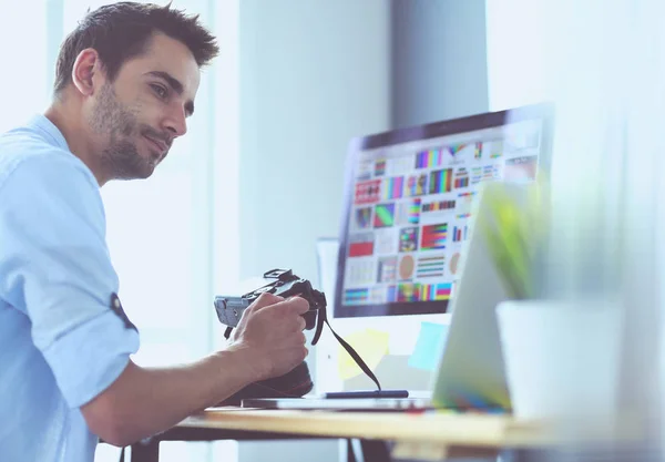 Porträt eines jungen Designers, der im Grafikstudio vor Laptop und Computer sitzt, während er online arbeitet. — Stockfoto