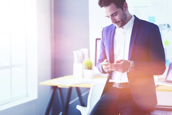 Joven diseñador escribiendo sms en su oficina — Foto de Stock