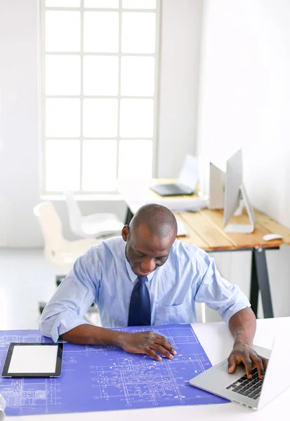 Architecte afro-américain travaillant avec l'ordinateur et les plans dans le bureau — Photo