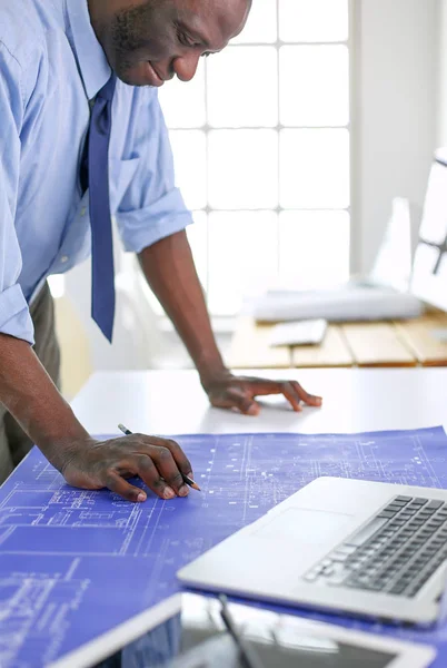 Afrikanischer Architekt arbeitet mit Computer und Bauplänen im Büro — Stockfoto