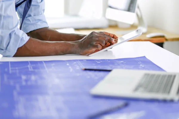 Arquitecto afroamericano trabajando con computadoras y planos en la oficina —  Fotos de Stock