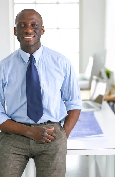 Retrato de un apuesto hombre de negocios negro de pie en el cargo —  Fotos de Stock