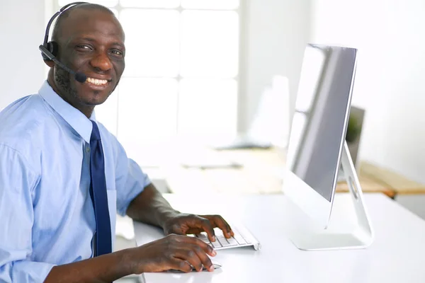 Homme d'affaires afro-américain sur casque de travail sur son ordinateur portable — Photo