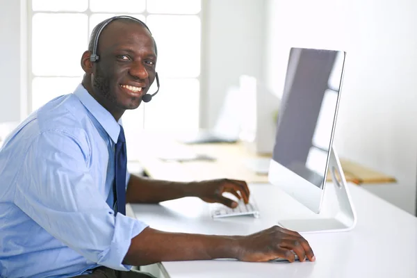 African american businessman on headset working on his laptop — Stock Photo, Image