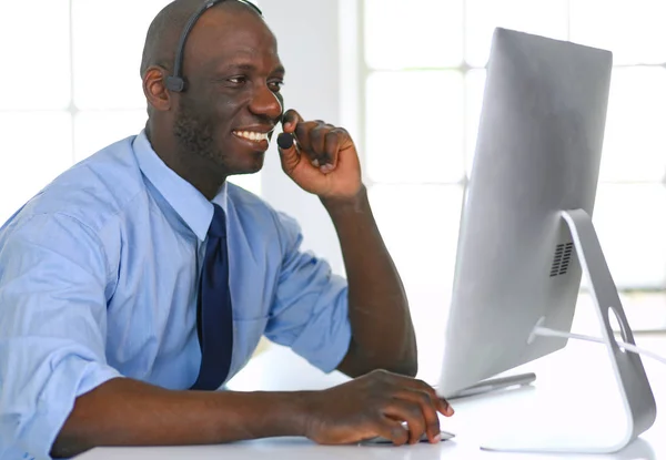 Homme d'affaires afro-américain sur casque de travail sur son ordinateur portable — Photo