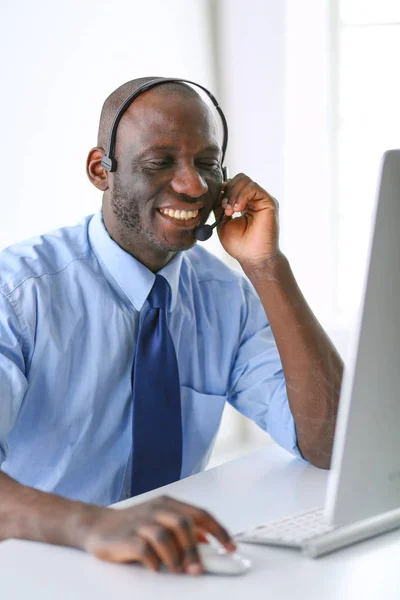 Homme d'affaires afro-américain sur casque de travail sur son ordinateur portable — Photo