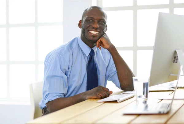 Afrikaans Amerikaans zakenman op headset werken op zijn laptop — Stockfoto