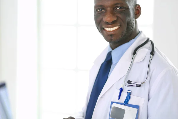 Male black doctor worker with tablet computer standing in hospital