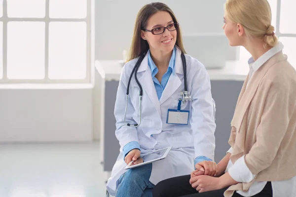 Médico e paciente discutindo algo enquanto se senta na mesa. Conceito de medicina e cuidados de saúde — Fotografia de Stock