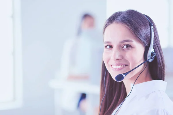 Mujer de negocios sonriente u operador de línea de ayuda con auriculares y computadora en la oficina — Foto de Stock