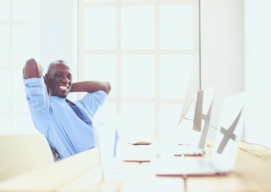 Kulaklıklı Afro-Amerikan işadamı laptopuyla çalışıyor.