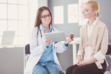 Doktor ve hasta masada otururken bir şey tartışıyorlar. İlaç ve sağlık hizmetleri kavramı