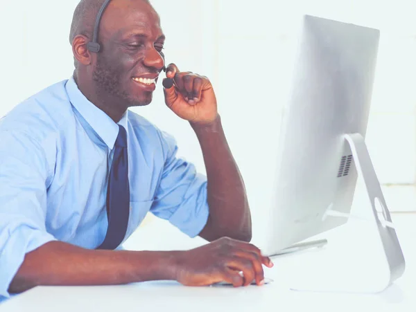 Afrikaans Amerikaans zakenman op headset werken op zijn laptop — Stockfoto