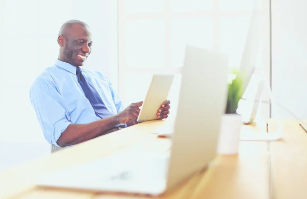 Afrikansk amerikansk affärsman på headset arbetar på sin bärbara dator — Stockfoto