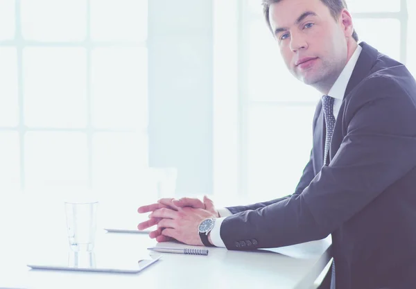 Porträt eines jungen Mannes, der an seinem Schreibtisch im Büro sitzt. — Stockfoto