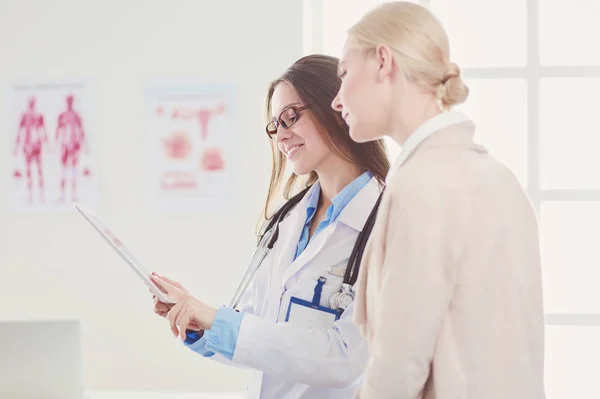 Dokter en patiënt bespreken iets terwijl ze aan tafel zitten. Begrip "geneeskunde en gezondheidszorg" — Stockfoto