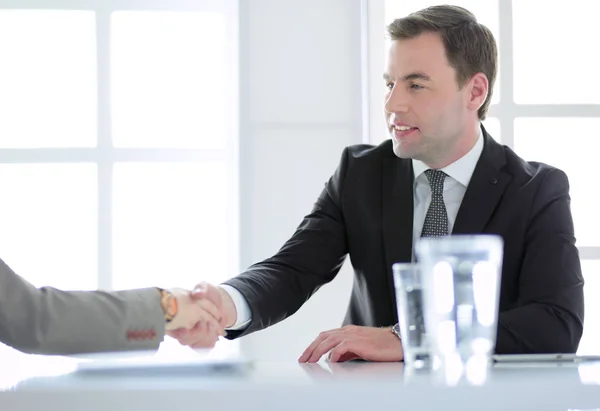 Porträt eines jungen Mannes, der an seinem Schreibtisch im Büro sitzt. — Stockfoto