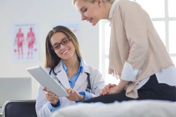 Doktorn och patienten diskuterar något när de sitter vid bordet. Medicin och hälsovård — Stockfoto