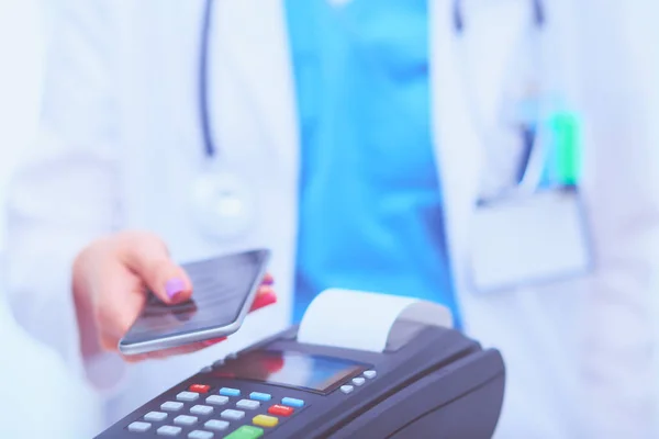 Doctor is holding payment terminal in hands. Paying for health care ...