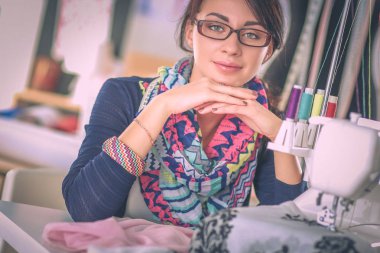 Çalışırken dikiş diken genç bir kadın.