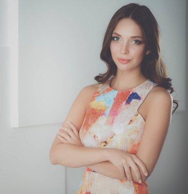 Beyaz arka planda poz veren güzel bir kadın.