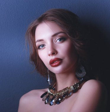 Siyah elbiseli, akşam makyajlı güzel bir kadın.