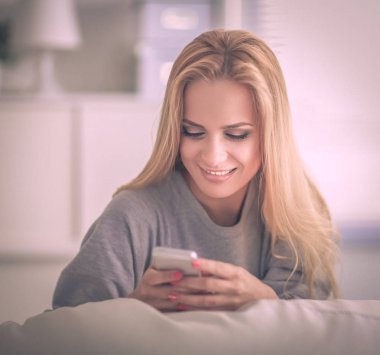 Oturma odasında kanepede mesaj gönderme yalan güzel kadın