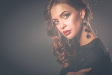 Siyah elbiseli, akşam makyajlı güzel bir kadın.