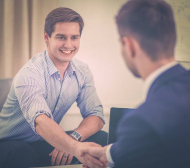 İş adamları toplantıda, ofiste oturup tartışıyorlar.