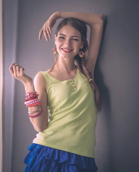 Young woman standing near dark wall — Stock Photo, Image