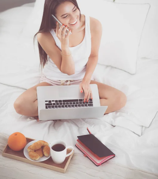 Jonge mooie vrouw zitten in bed — Stockfoto