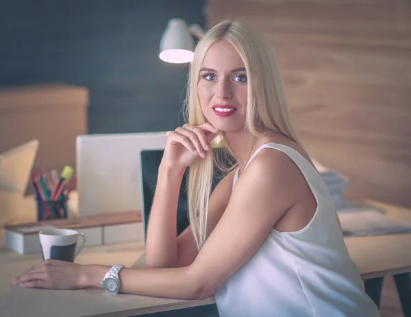 Fashion designers working in studio sitting on the desk — Stock Photo, Image