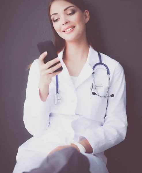 Mujer joven médico sentado con su teléfono — Foto de Stock