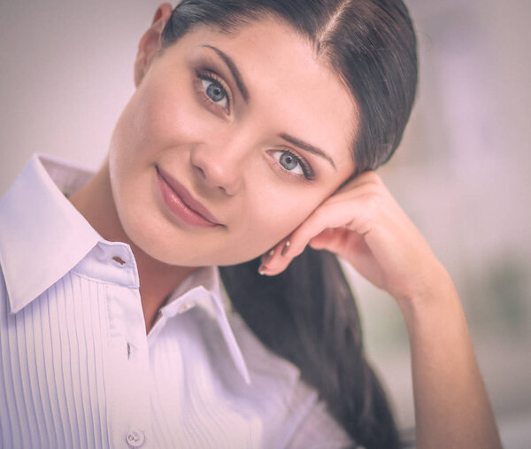 Привлекательная деловая женщина, сидящая на столе в офисе