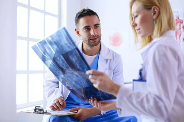 Bello medico sta parlando con giovane medico femminile e fare n — Foto Stock