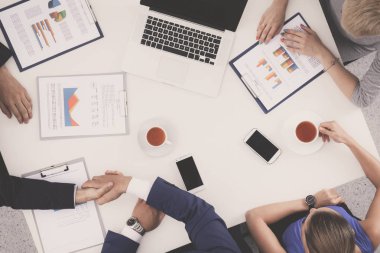 İş adamları iş toplantısında, ofiste oturup tartışıyorlar.