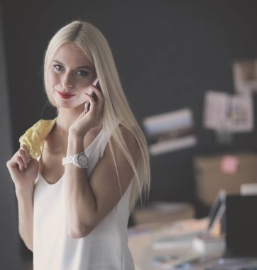 Grafik tasarımcı ofis cep telefonunda konuşuyor