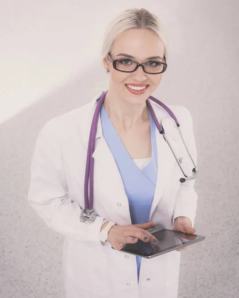 Female doctor using a digital tablet and standing on white background. Woman doctors.