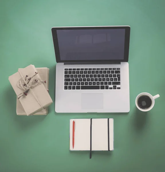 Notebook with gifts and laptop on wooden table — Stock Photo, Image